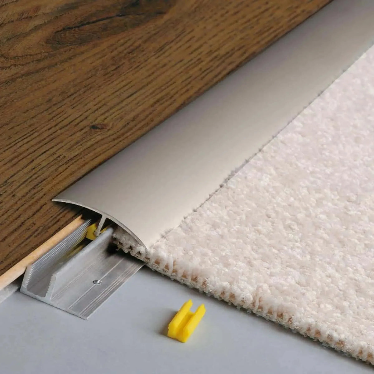 Profilé de compensation de hauteur CLIP anodisé en titane. Plancher en bois inséré brun d'un côté et moquette claire de l'autre. #FR0003687
#FR0003688
