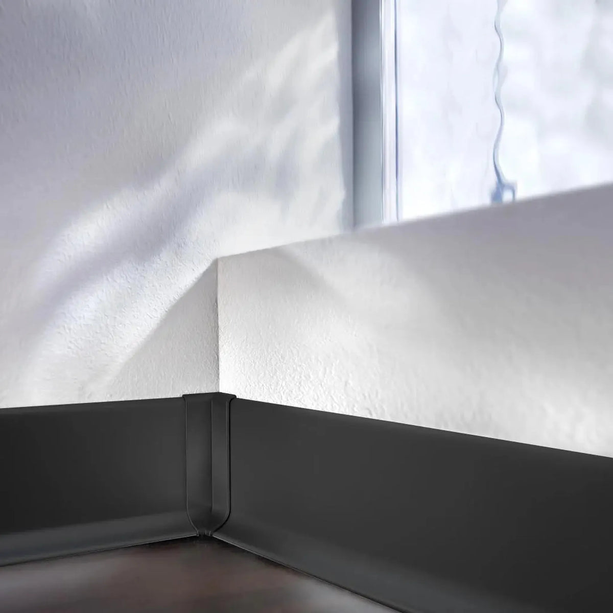 Skirting board installed on a wall with focus on the black inside corner skirting board aluminium #A0005091
#A0005096