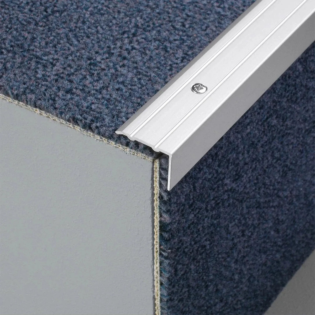 Gebohrtes Stufenprofil aus Aluminium silber matt in L-Form und geriffelter Oberfläche auf einer Treppe mit Teppich #A0005106 #A0005108