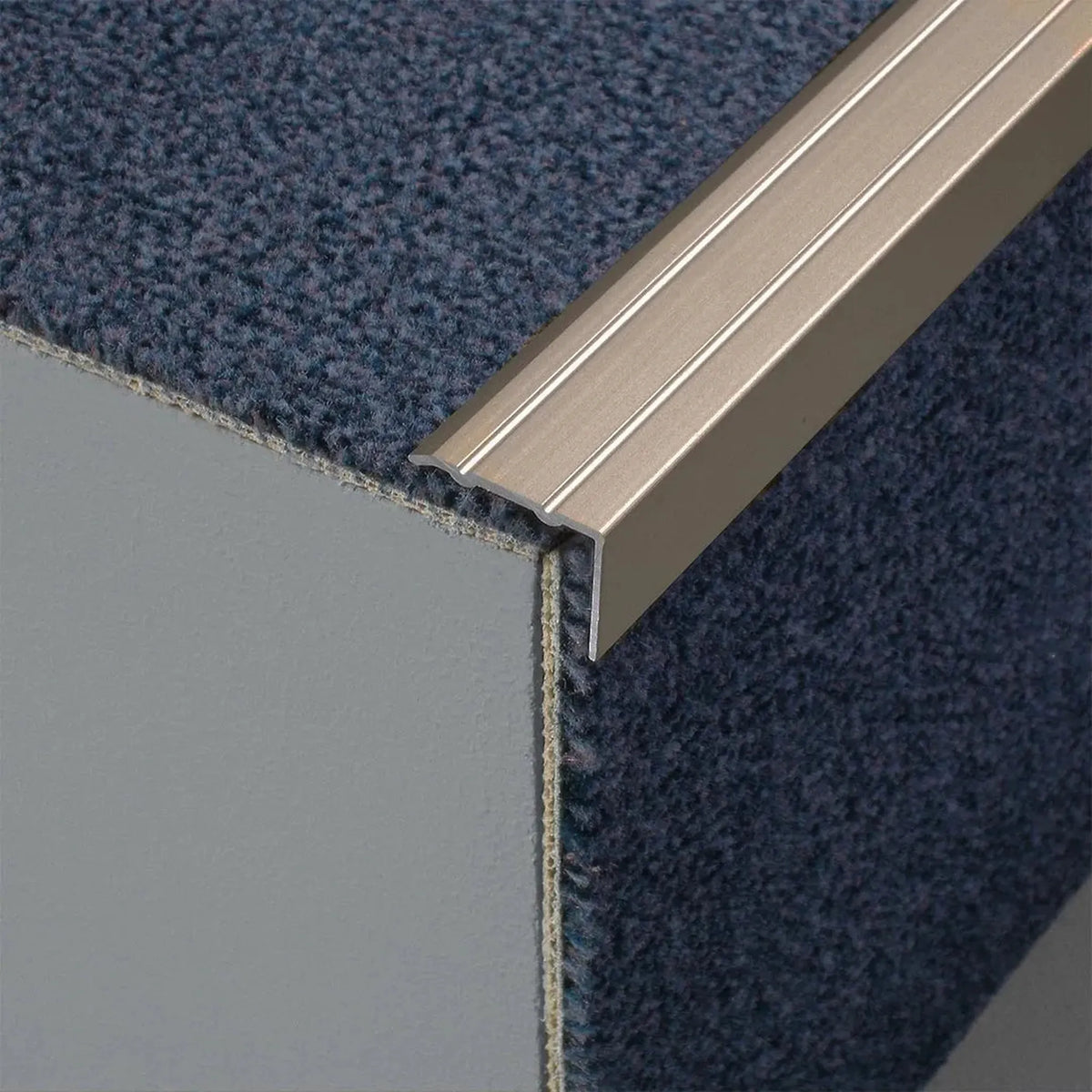 Profilé de nez de marche en aluminium titane mat en forme de L avec surface rainurée sur un escalier avec moquette #FR0005111
#FR0005113