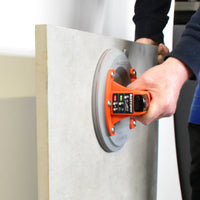Person lifting a tile at an angle with the Battipav suction lifter