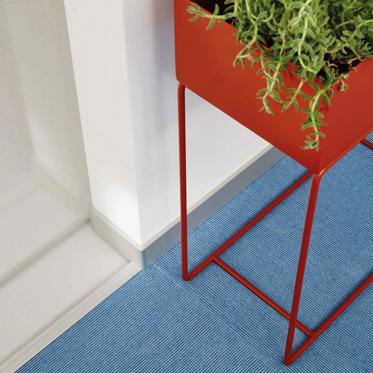 Ambientebild Sockelleiste in einem Fur verlegt vor der ein roter Blumentopf steht #A0002795