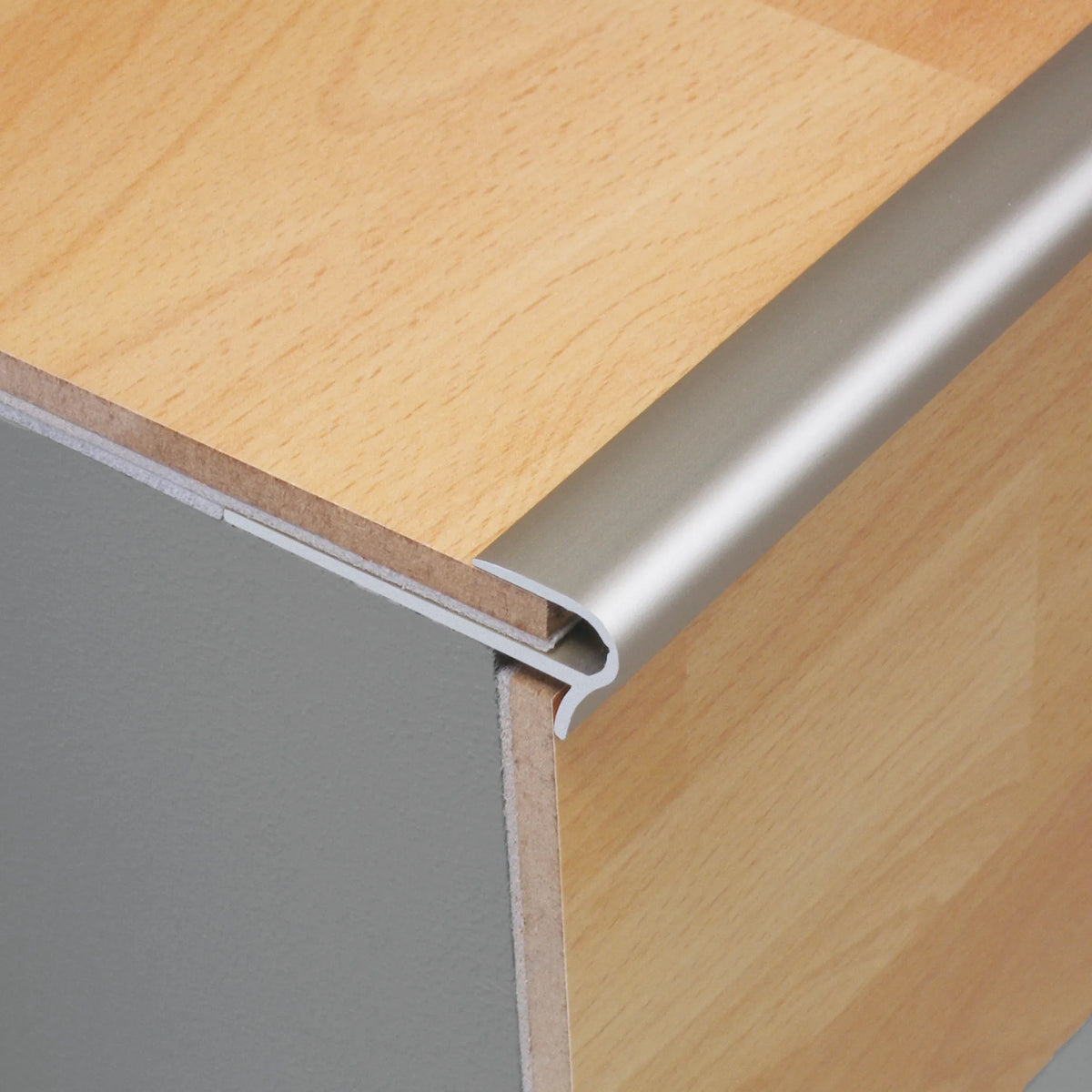Ambientebild Treppenstufen-Einschubprofil Aluminium silber matt eloxiert mit hellem Laminat verarbeitet